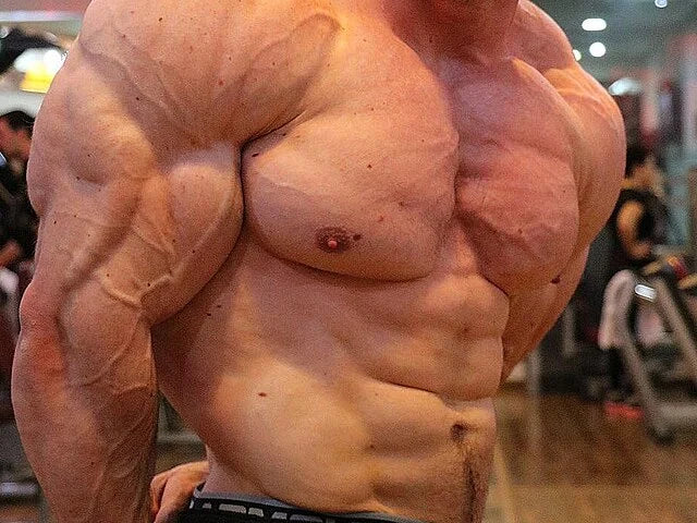 Muscular male torso in a gym, showcasing extreme muscle definition, strength, and stamina—ideal for illustrating natural muscle growth and fitness discussed in the blog.