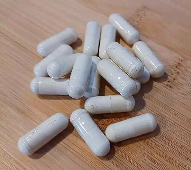 Vegan calcium supplement capsules on a wooden surface—cruelty-free, plant-based nutrition supporting ethical wellness and natural health.